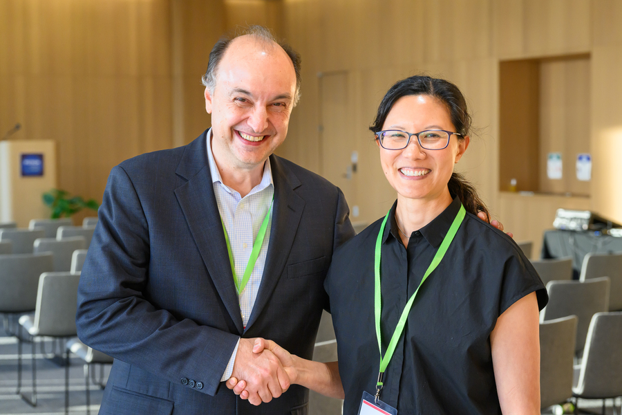 Vladimir Bulović and Joyce Wu pose and smile for the camera, shaking hands.