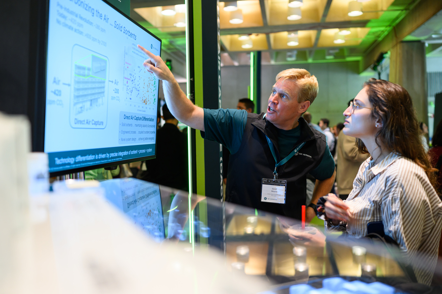 Two people look at a screen with text and figures.