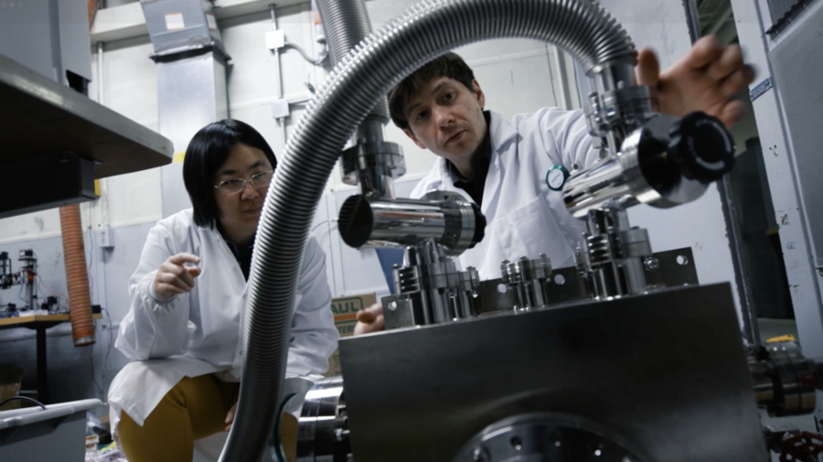 David Keisar and Sili Deng engage in a discussion in a lab, with equipment in the foreground