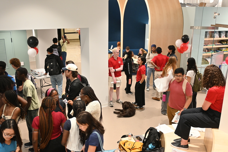 Students and staff mill about in a lounge space