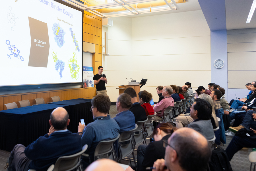 Hannes Stärk presenting slides to an audience inside of an auditorium.