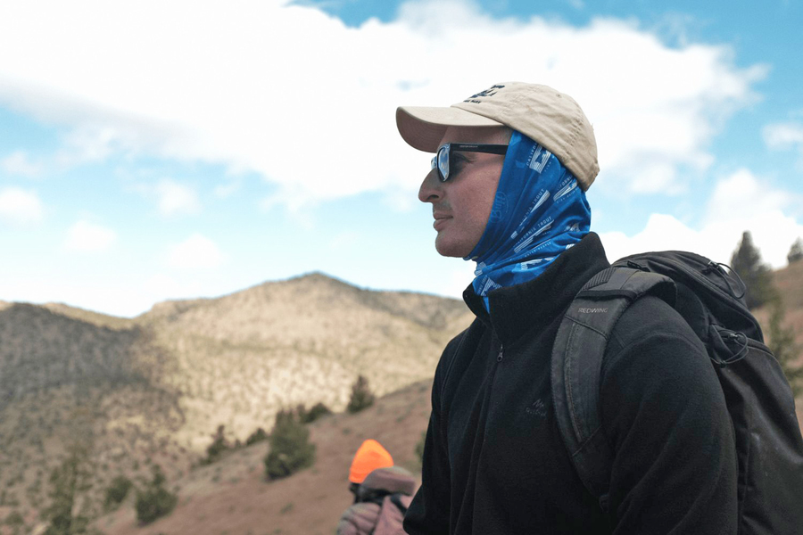 Dressed for cold weather, Justin Kay looks around a mountainous area