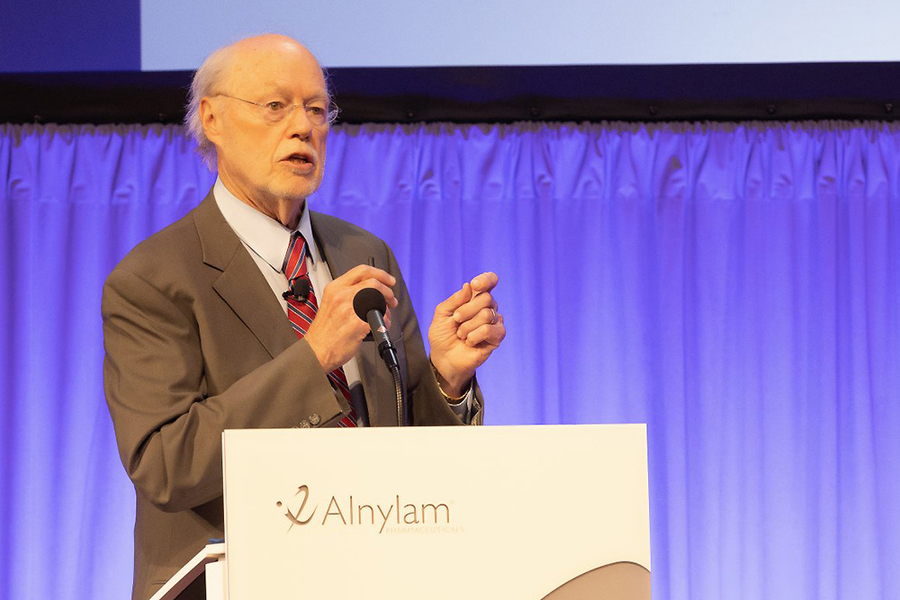 Phil Sharp standing and speaking at an Alnylam lectern