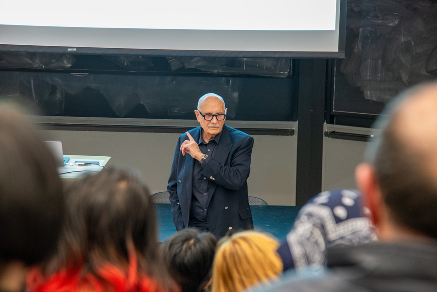 Diran Apelian stands at the front of an audience, gesturing while speaking
