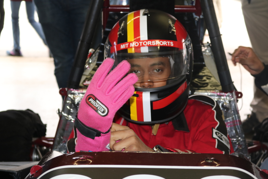 Close-up on the face of Faris Elnager in full racing gear, most of his face obscured by his helmet