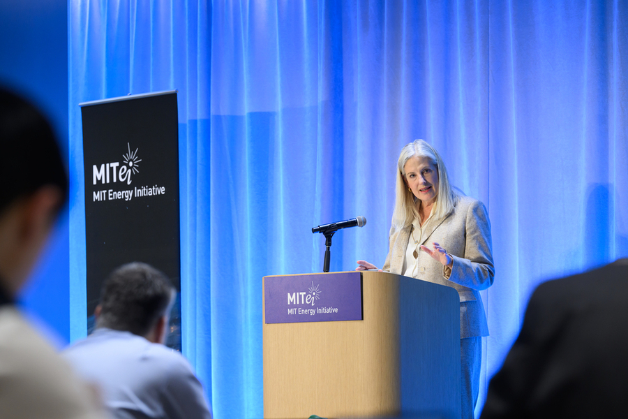 Karen Knutson speaks at a lectern on a stage indoors