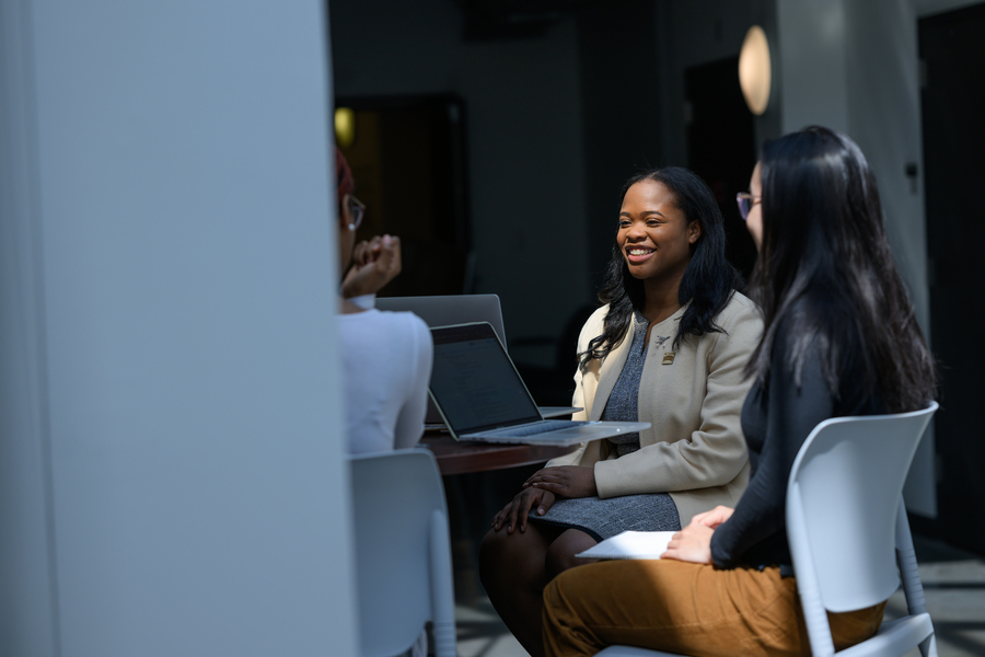 Carissma McGee sitting with other students at a table with laptops open