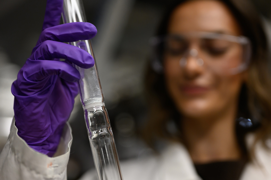 Audrey Parker holds a long glass device with a powdery mixture.