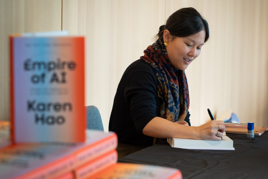 Karen Hao signs copies her book at the event.