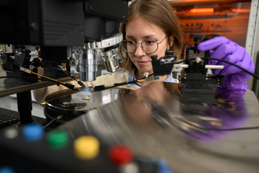 Camille Cunin peers intently at a sample under a microscope.