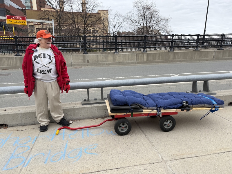 Martin Klein stands next to a wooden cart on one end of a bridge
