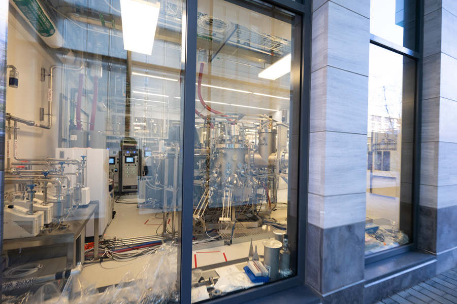 View through a laboratory window at a large, complex piece of machinery