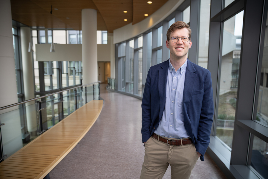 Emil Verner stands near windows in Sloan building. 