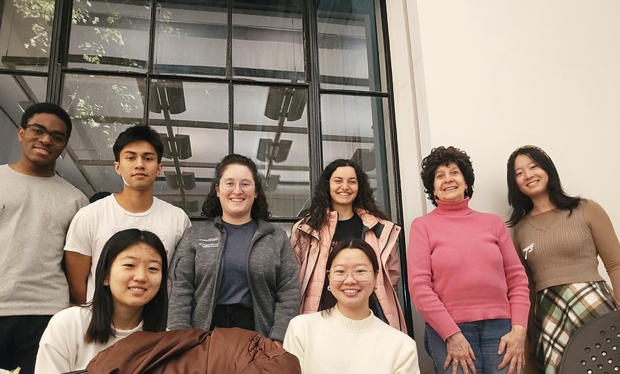 Group shot of 8 students outside a building