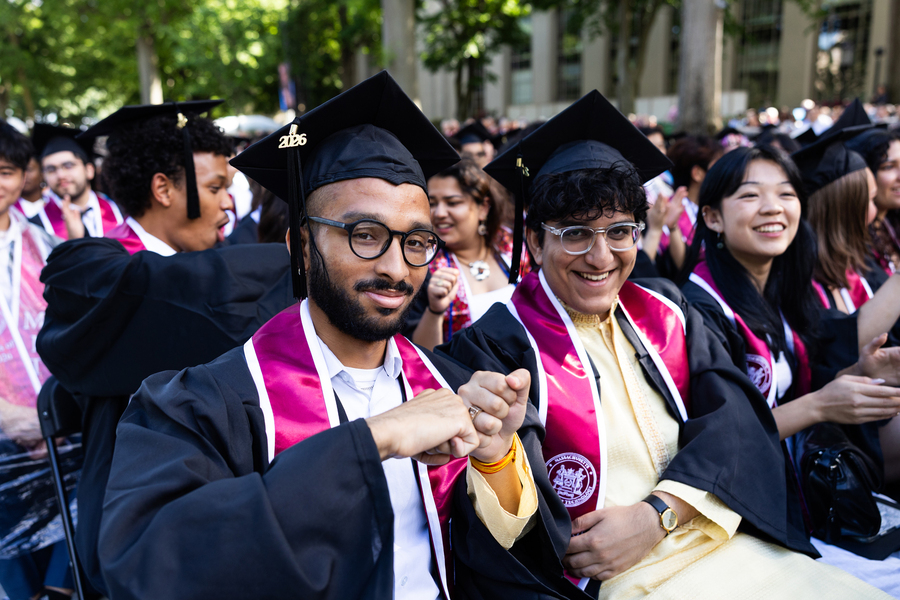 Graduates fist pump with their brass rat rings.