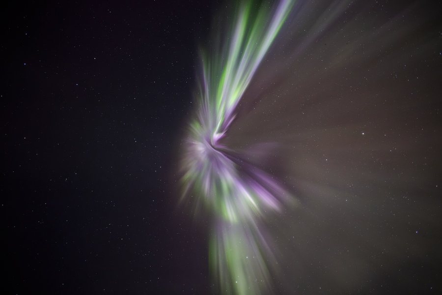 Colorful aurora forming a spiral pattern in the sky