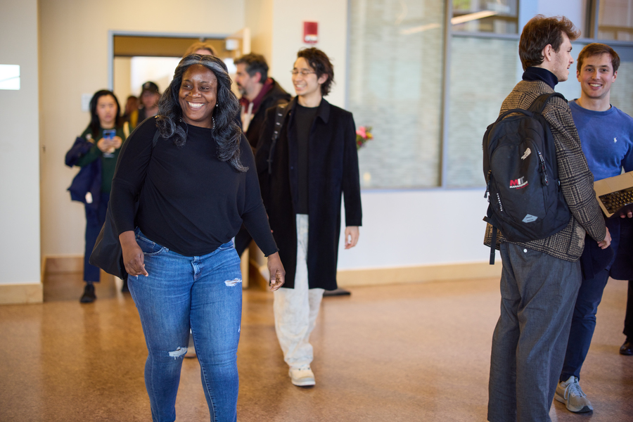 Asiamigbe walks into a busy hallway from a classroom