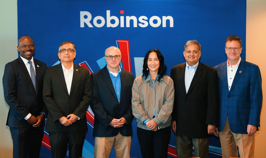 Six people stand in front of a blue event banner, with the word “Robinson” above them.