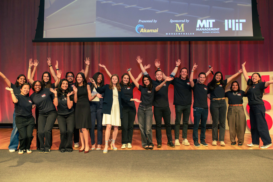 About 20 people on stage raise their hands in glee.