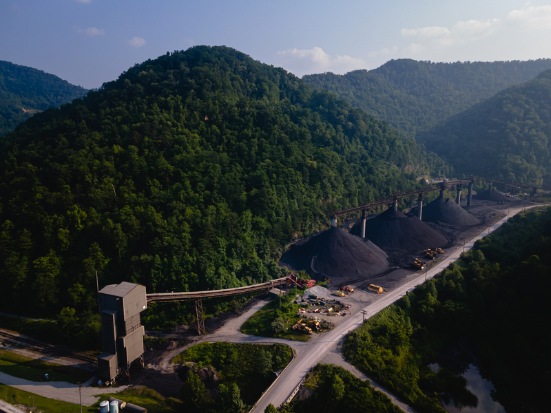 Aerial view of a coal processing facility along a road through a mountain area
