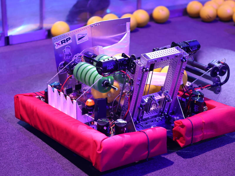 Timbot, a square robot with a padded chassis, with yellow foam balls in the background