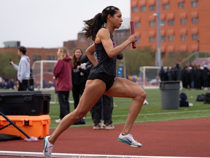 Krystal Montgomery carries a baton running on an outdoor track