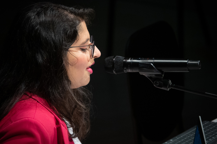 Nithya Shikarpur singing into a microphone.