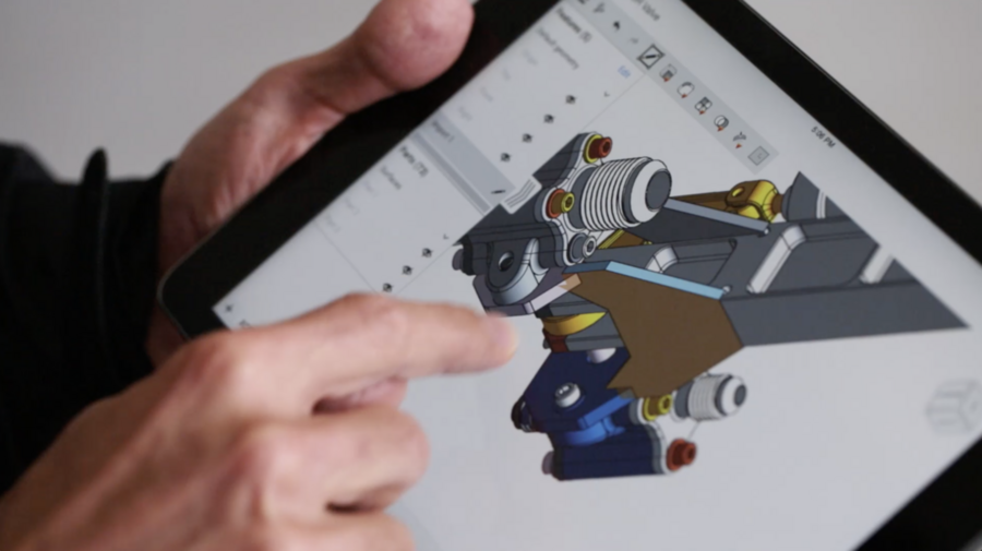 A finger points to a colorful 3D design drawing on a tablet computer