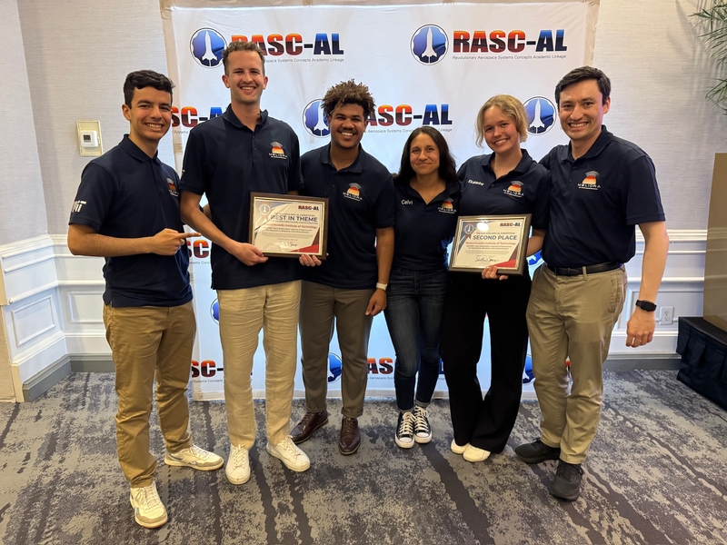 6 individuals wearing dark blue polo shirts pose together with their award certificates.
