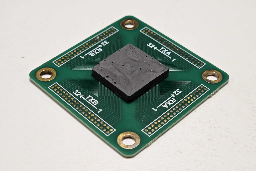 A square circuit board with black backing layer.
