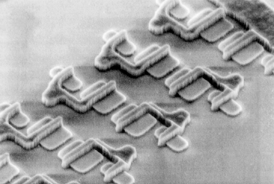 A scanning electron micrograph shows the tiny surface details of electrical devices.