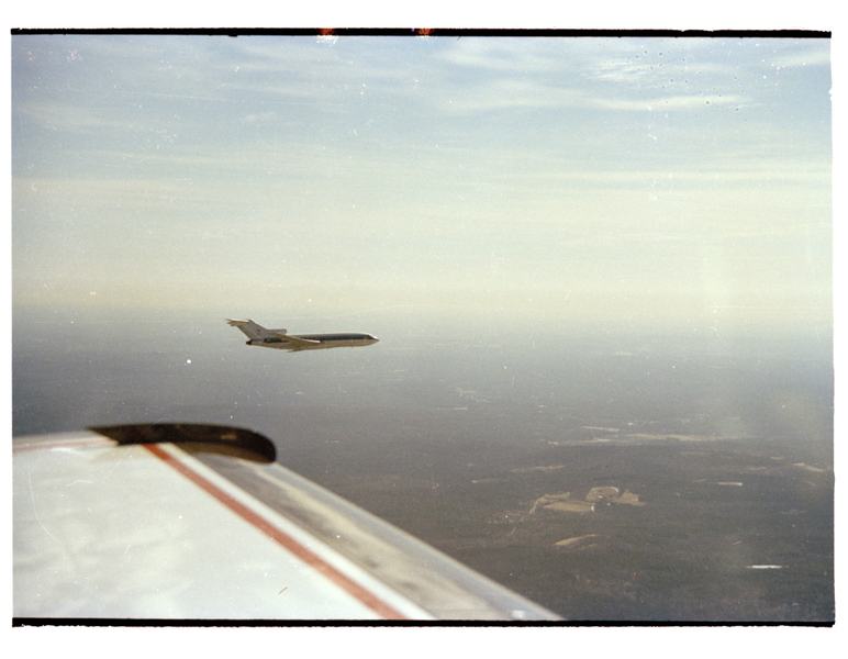 Two commercial aircraft fly in proximity. 