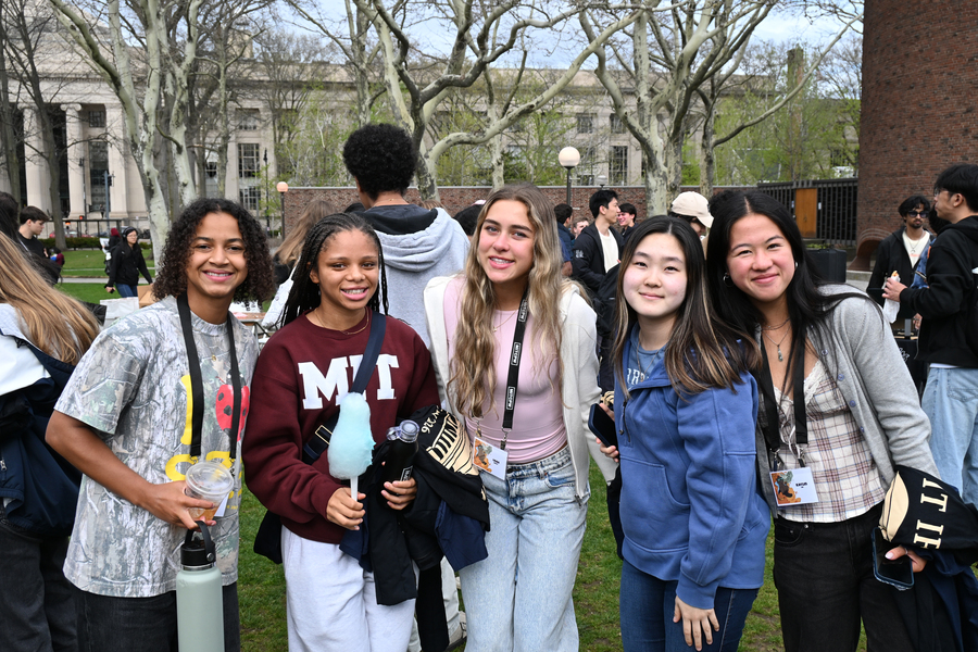 Five MIT students pose together on campus on a spring day