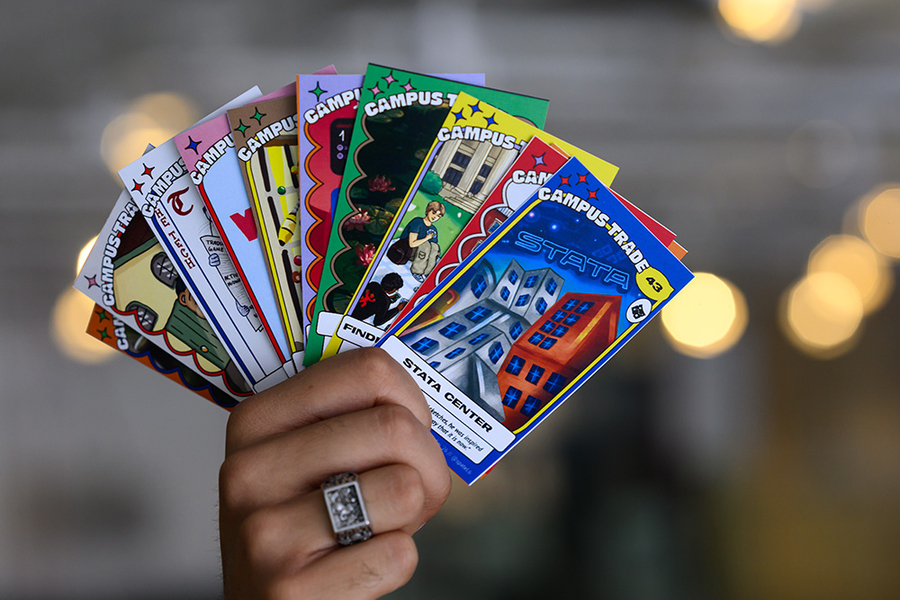 Photo of a hand holding 10 colorful trading cards