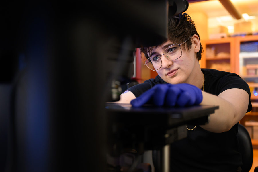 Closeup view of Shannon Knight placing a slide under a microscope