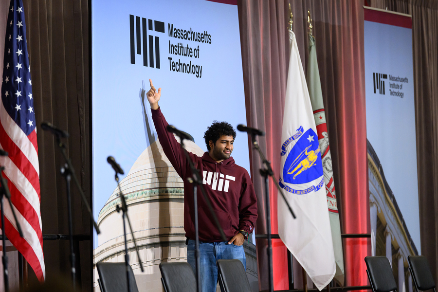 An MIT freshman in front of an MIT banner
