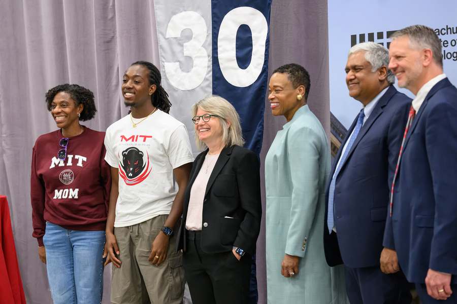 An incoming freshman and his mom being photographed with President Kornbluth and top administration