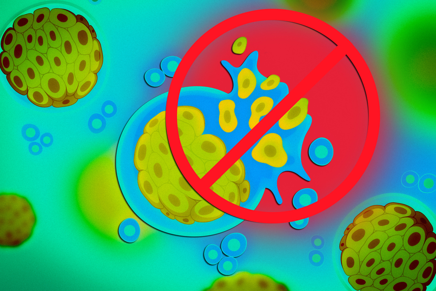 A big “X” sign over a splitting cancer cell.