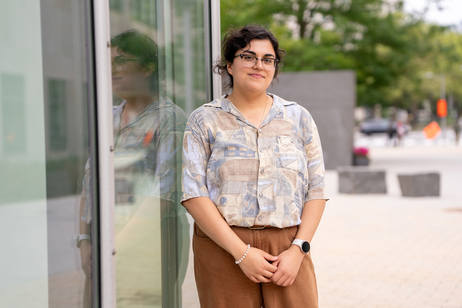 Faith Reyes stands near a window with her reflection.