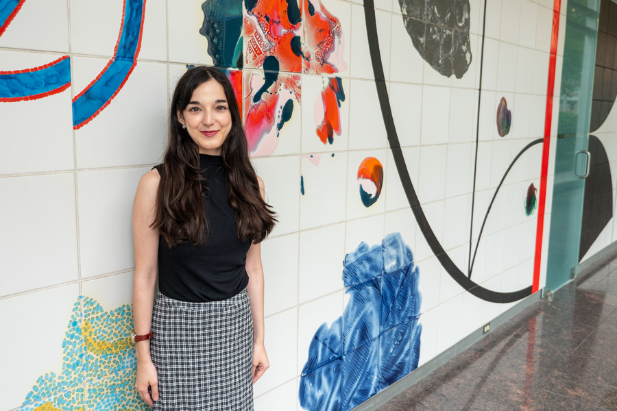 Marina Milea poses, standing, in a colorfully painted hallway