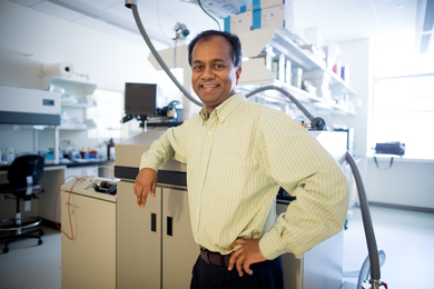 Photo of Ram Sasisekharan standing in a lab