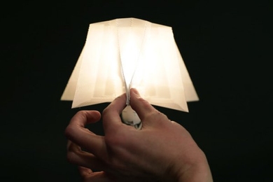 Photo of a hand holding up a 3D-printed lamp