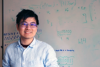 Photo of Sean Liu in front of work on a white board