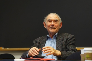 Photo of Julian Beinart seated before a blackboard