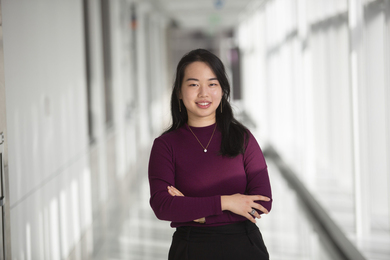 Jessica Xu standing in a corridor with her arms crossed