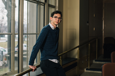David Darrow leaning against a windowsill in a classroom