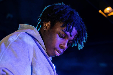 Photo of Dolapo Adedokun with a look of intense concentration on his face. He is bathed in blue light. 