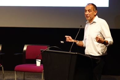 Munther Dahleh speaks at a podium in an indoor space