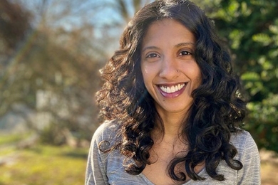 Athulya Aravind smiles against an out-of-focus outdoor background