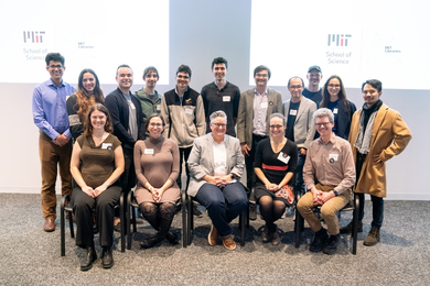 photographer research paper topics 16 people pose in two rows, one seated and one standing, for a group photo in MIT's Hayden Library.